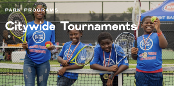 children with tennis rackets on a tennis court